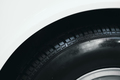 detail of car wheel black rubber tire on the front wing fender of white car - PhotoDune Item for Sale