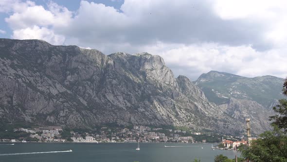 White Clouds Move Across the Blue Sky Above the Mountain Near the Town of Prcanj