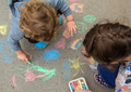 Children draw with chalk on the pavement. Selective focus. - PhotoDune Item for Sale