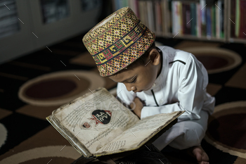 Smart school Asian boy reading an antique book at the Pedir Museum Aceh