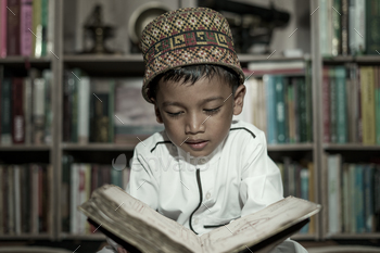 Smart school Asian boy reading an antique book at the Pedir Museum Aceh