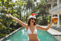Excited Woman in a Santa Hat at the Hotel Pool During Winter Holidays - PhotoDune Item for Sale