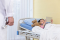 The doctor comes to check up a little girl who playing an iPad with a bear on the hospital bed. - PhotoDune Item for Sale