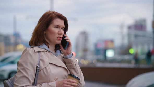 Business Woman Standing on Parking Lot and Talking on Phone
