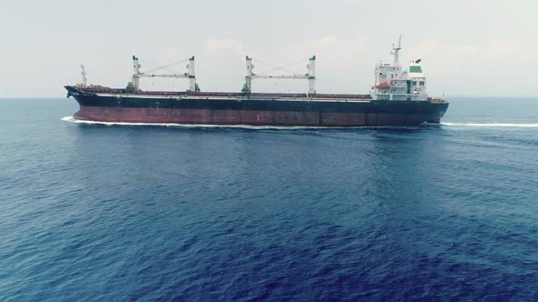 Drone Side View Of Commercial Ship Vessel On Deep Blue Sea