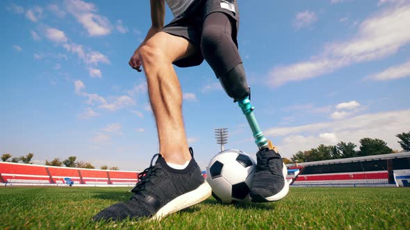 Male Player with a Bionic Leg Is Practicing with a Ball