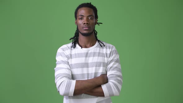 Young Handsome African Man with Dreadlocks Against Green Background