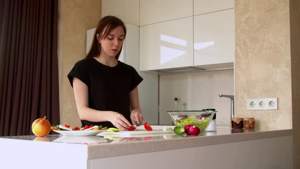 Woman Cutting Tomatoes in Kitchen 