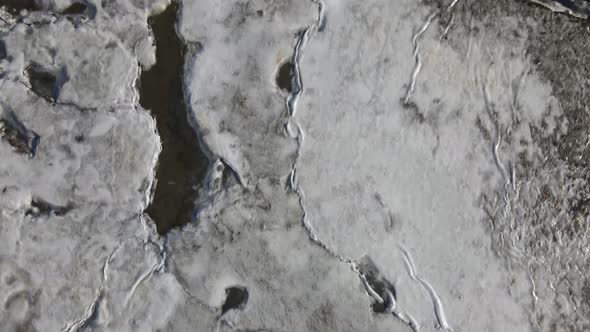 Aerial footage of frozen marshland, natural landscape looking directly down.  Drone birds eye