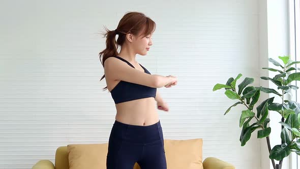 Healthy beautiful Asian woman Exercise in the living room at home.