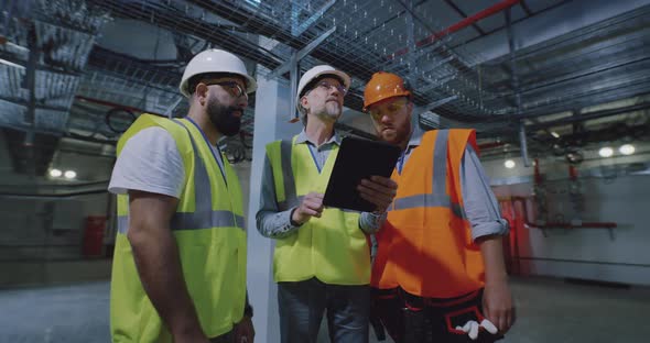 Engineers Inspecting Dark Workshop of Power Plant