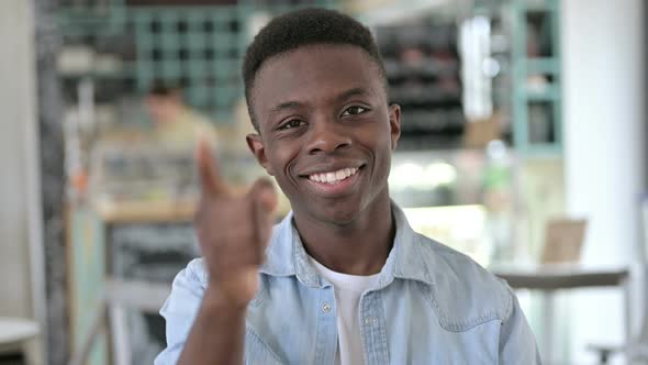 Portrait of Happy Young African Man Pointing with Finger