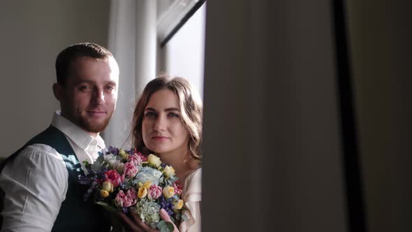 A Couple in Love Stands Near a Window