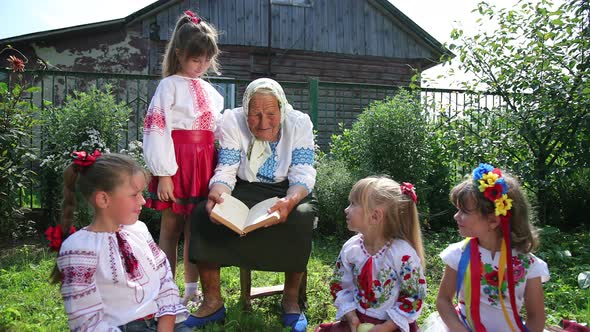 An Old Grandmother is Sitting on the Street and Reading a Book