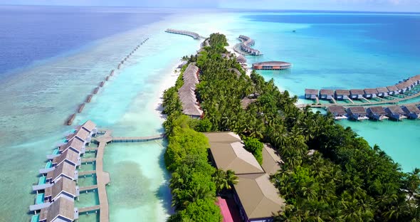 Daytime above travel shot of a sandy white paradise beach and aqua blue water background in high res