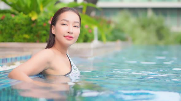 Young asian woman enjoy around outdoor swimming pool for leisure