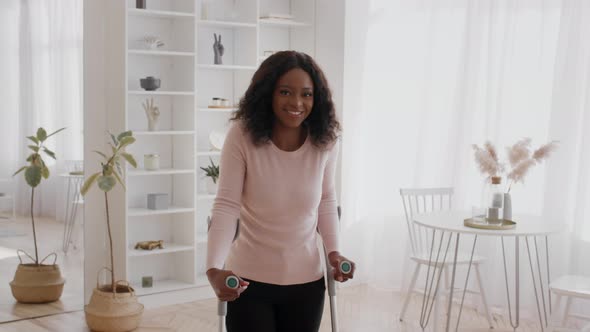 African Lady With Disability Standing With Crutches Smiling At Home