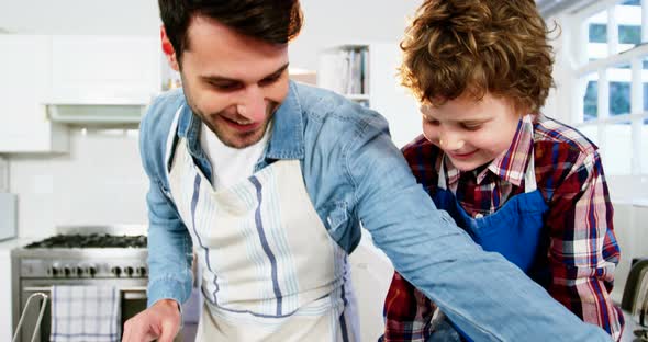 Father teaching his son how to make cupcake