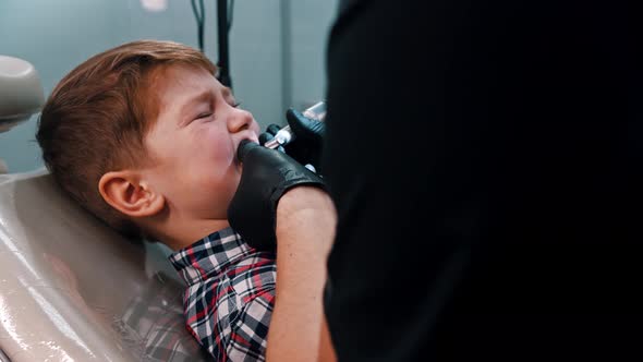 A Little Stressful Boy Polishing His Teeth in the Dentistry