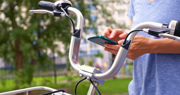 Woman rent an electric bike using mobile phone apps.
