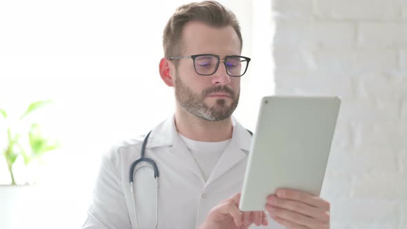 Portrait of Attractive Doctor Using Tablet in Office