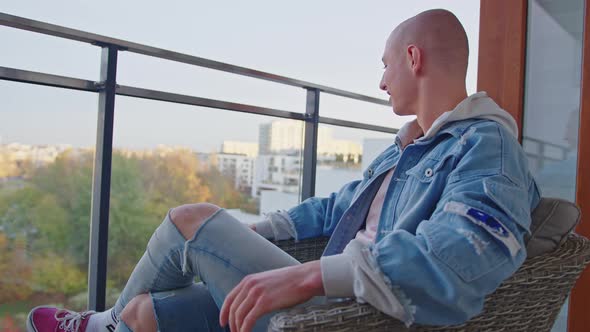 Caucasian Bald Gay Man Relaxing on His Balcony Enjoying Fresh Air and Good Weather