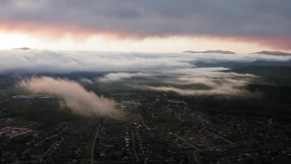 Aerial Drone Sunrise View Over Foggy Countryside with Wooden Houses