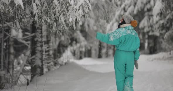 Woman in Ski Suit in Snowy Forest During Winter Vacations Outdoors