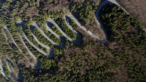 Aerial trucking shot of winding road over Bratocea Pass, Romania