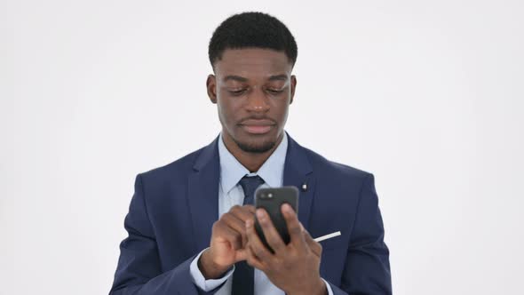 African Businessman Browsing Smartphone on White Background