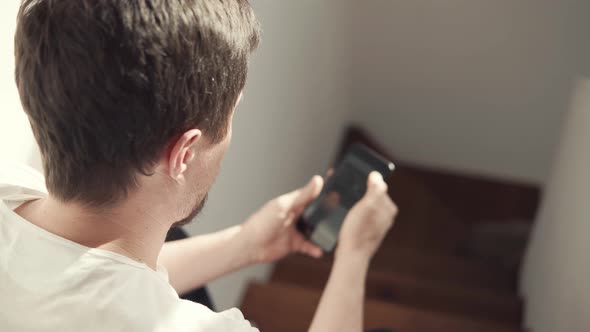 a Young Man Uses a Mobile Phone and the Internet To Buy Online Things