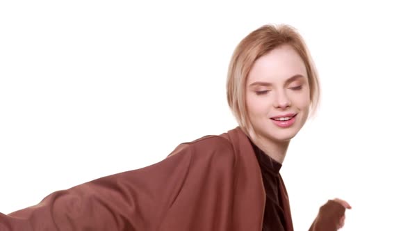 Relaxed Young Beautiful Caucasian Girl Dancing Smiling on White Background in Slowmotion