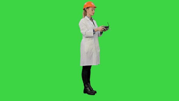 Female Engineer Correct Parts of an Object Using Remote Controller on a Green Screen, Chroma Key