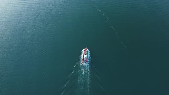 An aerial view from a drone flying above a fishing boat