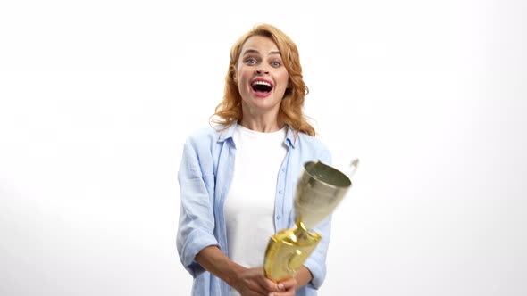 Extremely Happy Girl with Champion Gold Cup Kissing the Prize Trophy