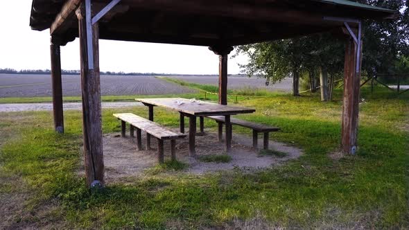 Wooden Benches Surround Table in Pavilion with Green Roof