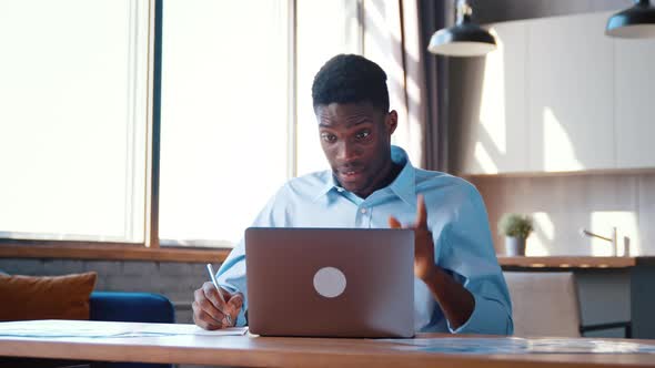 Young businessman communicating with his colleague via video call remotely