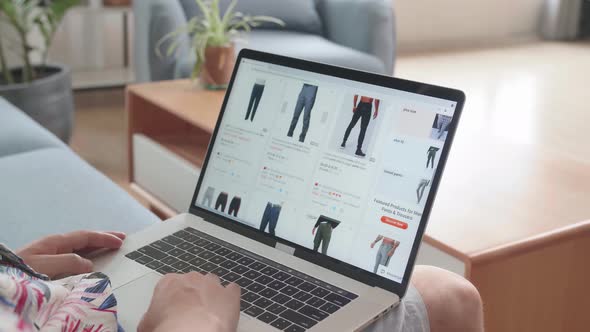 Asian Man Sitting On Couch And Buy Fashion Clothes Directly On Laptop Computer