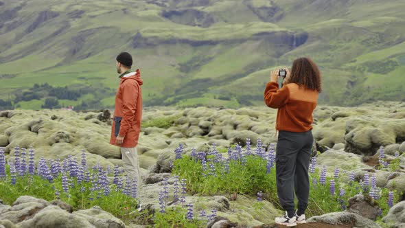 Hiker Photographing Male Partner In Mossy Landscape