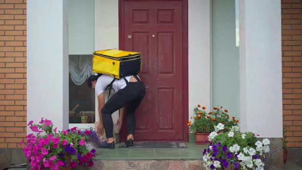 Back View Courier Leaving Parcel at Entrance Knocking in Door Walking Away