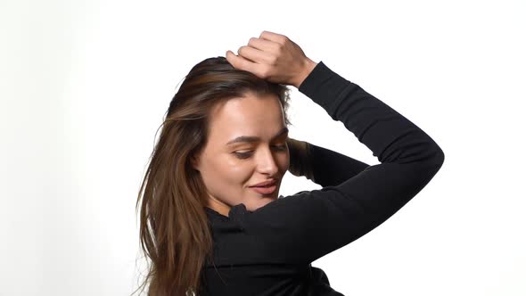 Woman with hairstyle trembling from laugh. Smiling positively and being in great mood while standing