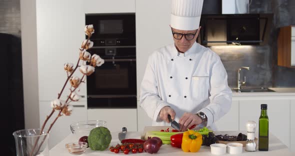 Aged Chef in Uniform Chopping Tomatoes Cooking Vegetarian Meal