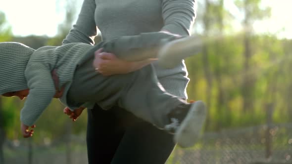 Young Mother Playing, Hugging Her Little Baby Boy. Mom Is Spinning in Arms Her Son. Love, Family