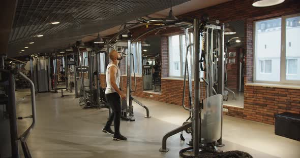 Athlete Walks Across the Gym Pullup Bar Bodybuilder with Strong Athletic Build