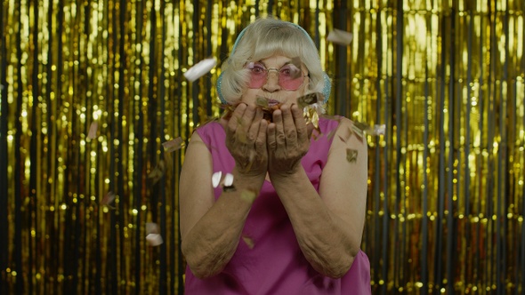 Happy Mature Old Woman Laughing, Blowing Confetti Glitters, Celebrating Birthday, Winning Lottery