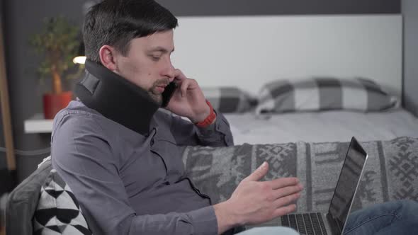 Man in Neck Brace Cervical Collar Working From Home Teleworking