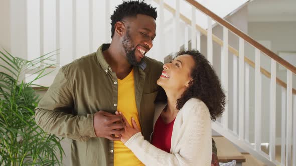 Happy arfican american couple embracing and looking at camera