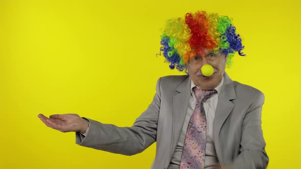 Elderly Clown Businessman Entrepreneur Boss Pointing at Something. Copy Space