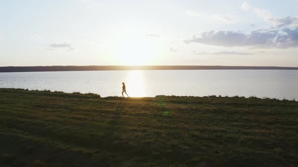 Aerial Shot of Young Woman Enjoying Sunset in Field and Running Near the Cliff During Beatiful