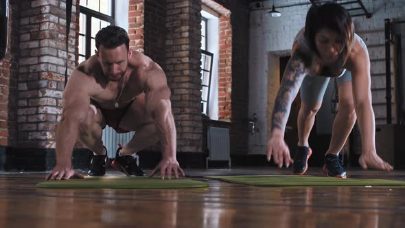 Couple Training in the Gym  Doing Push Ups Together on Yoga Mats